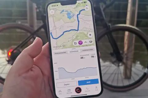 Mapa z trasą rowerową na telefonie, pokazująca drogi leśne dopuszczone do ruchu. Widok profilu wysokości i przycisk "Jedź".