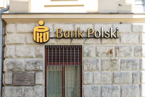 PKO Bank Polski oferuje pko kredyt hipoteczny bez wkładu własnego. Złote logo banku na kamiennej fasadzie.