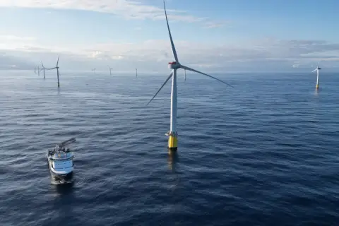 Morskie farmy wiatrowe w Polsce rozwijają się na Bałtyku. Statek serwisowy zbliża się do jednej z turbin.