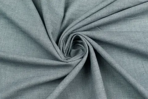 Szara wiskoza, zwinięta w spiralę. Czy wiskoza się gniecie? Ten materiał wygląda na miękki i podatny na zagniecenia.