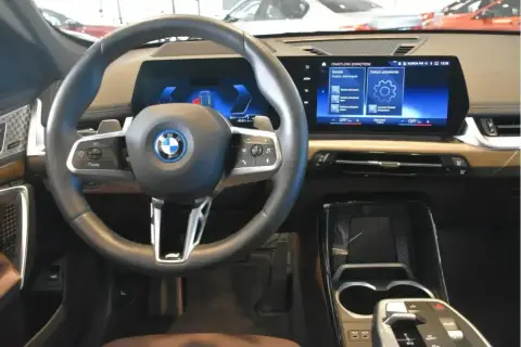 Wnętrze BMW X1 z nowoczesnym ekranem i kierownicą. Sprawdź aktualną bmw x1 cena i wyposażenie.