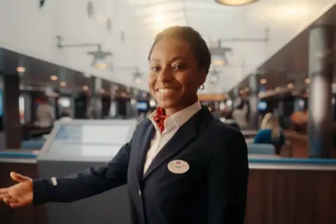 Uśmiechnięta pracownica Stena Line zaprasza na pokład. Skorzystaj z kodu promocyjnego Stena Line i rozpocznij podróż!