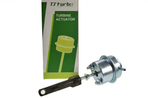 Zawór podciśnienia turbiny Ford Focus 1.6 TDCI. Element metalowy z grzybkiem i regulowanym ramieniem, obok zielono-białe opakowanie z napisem "TURBINE ACTUATOR".