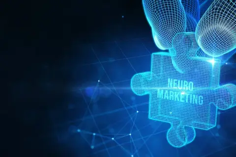 Cyfrowa łamigłówka z napisem "NEURO MARKETING" w technologii siatkowej, trzymana przez dłoń.