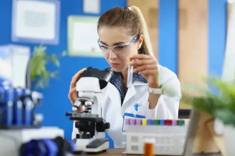 Studentka na biotechnologia studia bada próbkę pod mikroskopem.