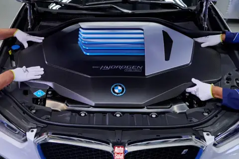 Ręce w białych rękawiczkach montują osłonę silnika BMW i Hydrogen Fuel Cell.