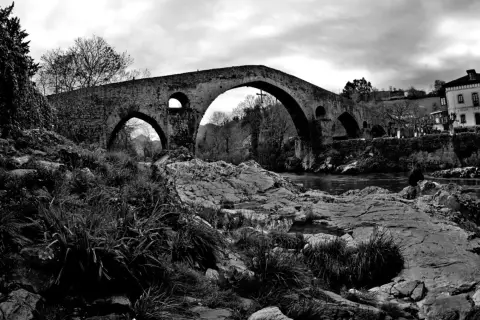 Puente medieval de piedra en Cangas de Onís, ideal para descubrir qué hacer en la zona. Naturaleza y historia se unen.