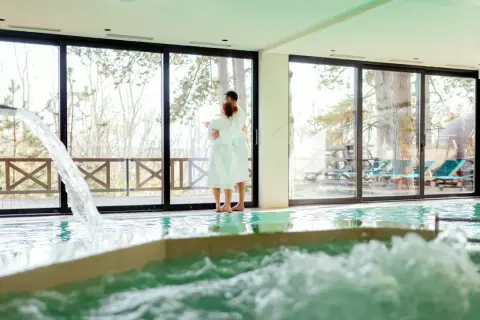 Pareja abrazada en un spa, disfrutando de la piscina y la vista. Así se hace en un spa: relajación y conexión.