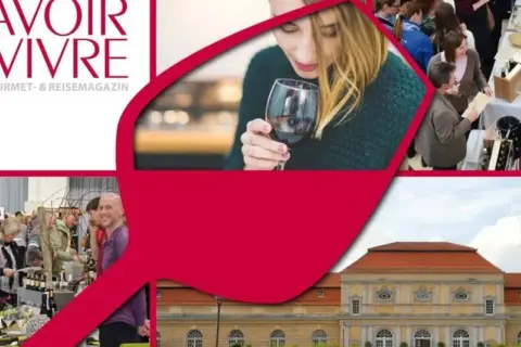 Menschen genießen Wein auf einem Fest. Ein Magazin-Logo "Savoir Vivre" ist zu sehen. Ein Gebäude im Hintergrund.