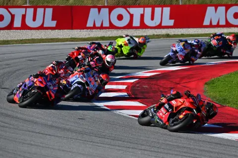 Carreras de MotoGP en curva, pilotos luchando por posición. El calendario MotoGP se llena de adrenalina.