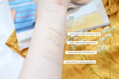 Smugi podkładów na przedramieniu: Estee Lauder, Catrice i Missha.