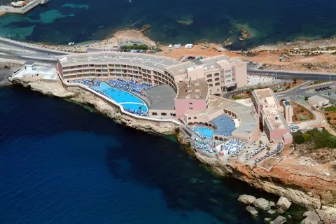 Widok z lotu ptaka na Paradise Bay Resort z basenami i leżakami, położony na klifie nad turkusowym morzem.