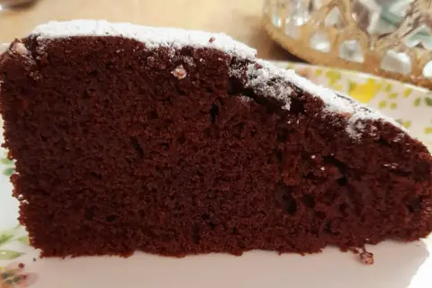 Una fetta di torta al cioccolato soffice, spolverata di zucchero a velo. Un'idea golosa per una torta mascarpone e cioccolato.