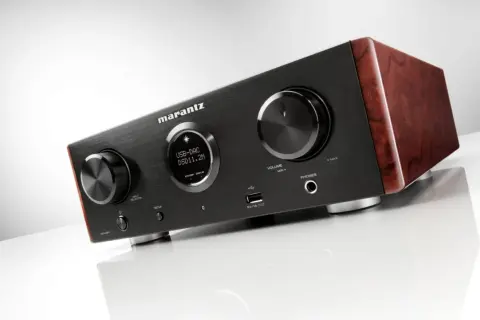Elegancki wzmacniacz Marantz HD AMP1 z drewnianymi panelami bocznymi, wyświetlaczem USB-DAC i pokrętłami.