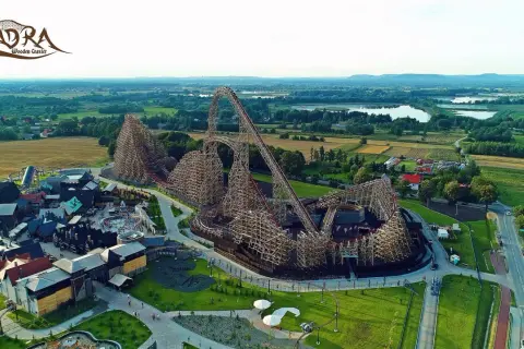 Drewniany rollercoaster Zadra w parku rozrywki, z widokiem na okoliczne pola i jeziora. Zastanawiasz się, ile jedzie Zadra?