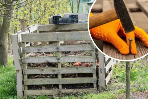 Budowa kompostownika z palet. Ręka w pomarańczowej rękawicy wbija gwóźdź młotkiem, tworząc solidną konstrukcję do kompostowania resztek organicznych.