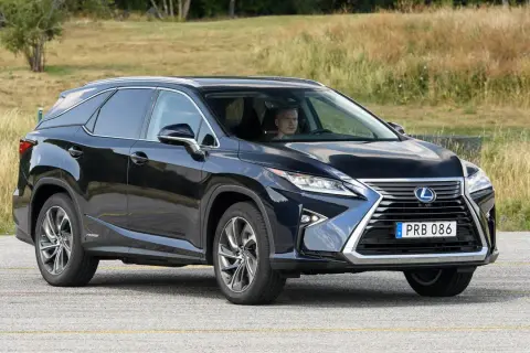 Mörkblå Lexus RX 450h körs på en väg, föraren ser ut att ha ett lexus rx 450h problem.
