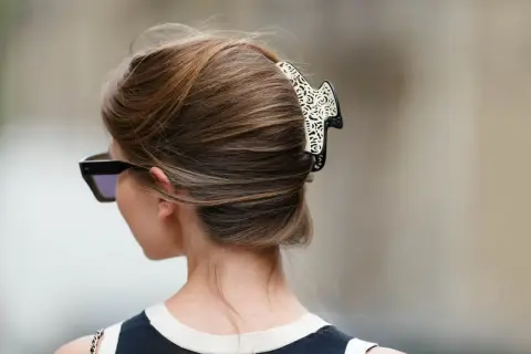 Elegancki french twist z ozdobną spinką, podkreślający szyję i okulary przeciwsłoneczne.
