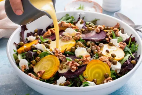 Una ensalada vibrante con remolachas, queso de cabra y nueces, bañada con deliciosas salsas para ensaladas.