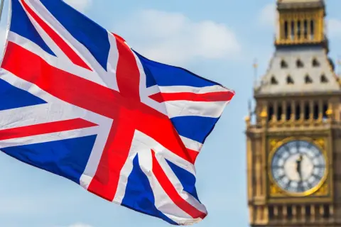 Flaga Wielkiej Brytanii powiewa przed Big Benem. Marzysz o podróży i potrzebujesz wiza do UK?