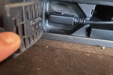 Kabel AUX podłączony do gniazda, gdy **bluetooth przerywa**. Palec przytrzymuje klapkę.