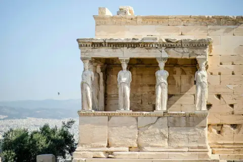 Erechtheion, świątynia Ateny, z kariatydami podtrzymującymi dach. W tle Ateny i góry.