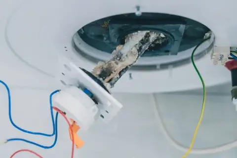Détartrage chauffe eau : résistance entartrée et câblage apparent. Accumulation de calcaire sur la résistance.