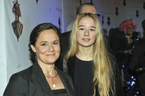 Pernilla August med sitt barn på en tillställning.