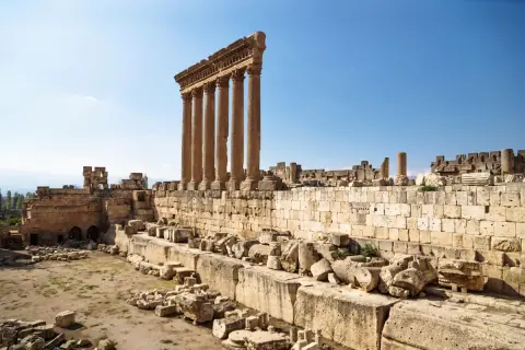 Majestätische Säulen des Baalbek Tempels ragen in den blauen Himmel. Antike Ruinen und Steine zeugen von vergangener Größe.