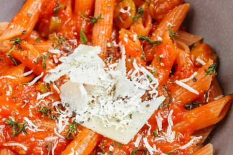 Penne w sosie pomidorowym z oliwkami i parmezanem. Idealny przepis na makaron z sosem, który zachwyci każdego.