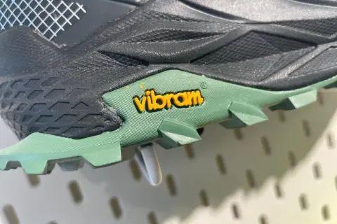 Nahaufnahme einer grünen Vibram Sohle mit gelbem Logo. Mögliche Nachteile: Abnutzung, aber die Traktion ist gut.