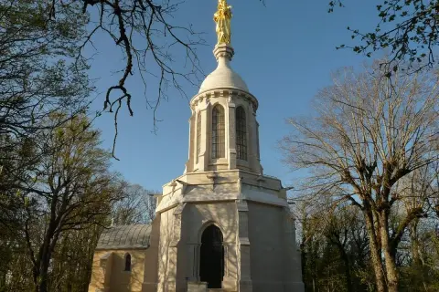 Chapelle de Notre-Dame d'Afrique à Dijon, dominée par une statue dorée. Un lieu de quiétude au cœur de la nature.