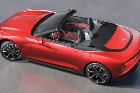 Czerwony MG Roadster z otwartym dachem, sportowe fotele i kierownica.