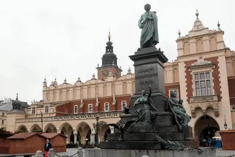 Pomnik Adama Mickiewicza na Rynku w Krakowie, z Sukiennicami w tle.