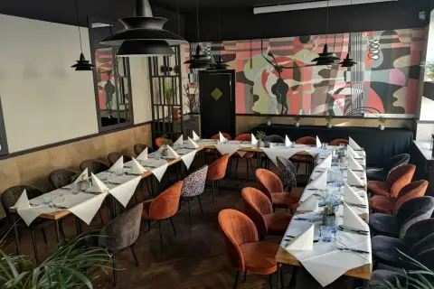 Elegancka sala bankietowa z nakrytymi stołami, idealna na wyjątkowe okazje. To może być najlepsza restauracja w Olsztynie.