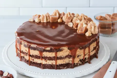 Schokoladenkuchen mit Karamellcreme und Nüssen, überzogen mit glänzender Schokoladenglasur. Eine köstliche Nuss Karamell Torte.
