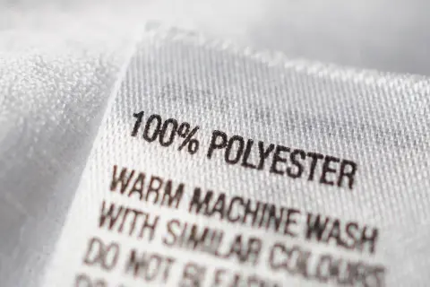 Etikett zeigt "100% POLYESTER". Ist Polyester gut? Ja, es ist pflegeleicht und langlebig.