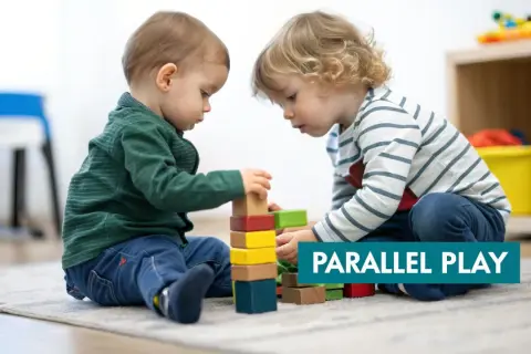 Two toddlers build with blocks, demonstrating the benefits of parallel play.