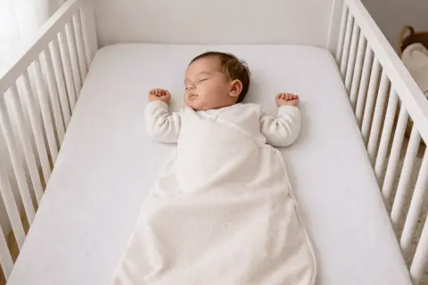 Un bébé dort paisiblement dans son berceau. Cette image rappelle l'importance de la vigilance pour prévenir la mort subite du nourrisson.