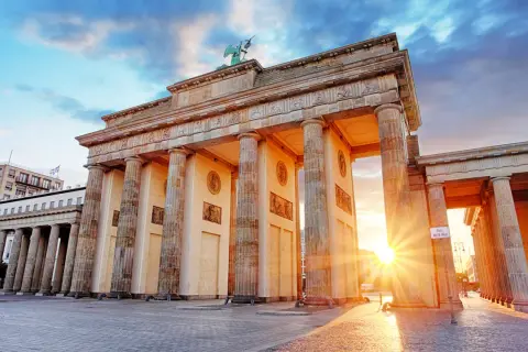 Brandenburger Tor i Berlin, en ikonisk symbol för staden, perfekt för din berlin reseguide. Solnedgången lyser upp monumentet.