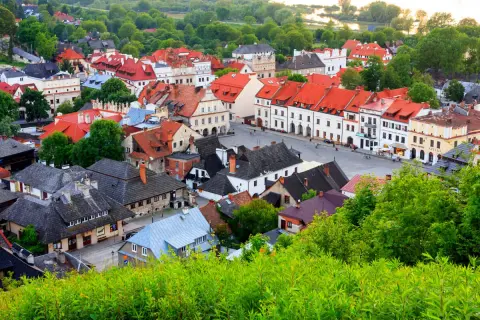 Urokliwe miasteczko z czerwonymi dachami, idealne na weekend w Lubelskiem. Zieleń otacza zabytkowe kamienice.