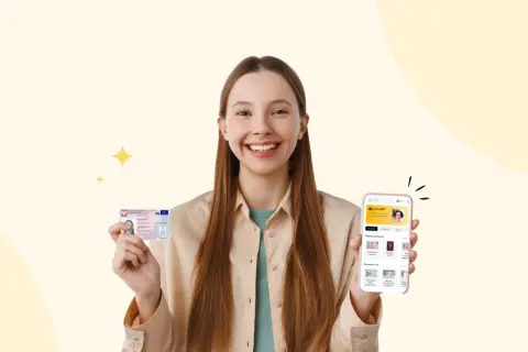 Uśmiechnięta dziewczyna trzyma dowód osobisty i smartfon z aplikacją do zdjęć do dowodu.