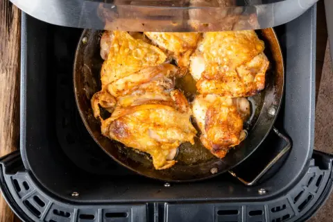 Pechuga de pollo dorada y jugosa cocinándose en una freidora de aire.