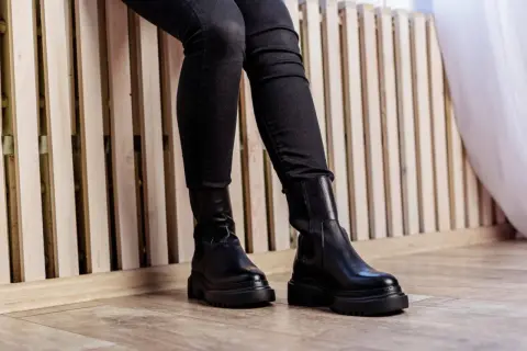 Czarne, dopasowane spodnie i masywne botki za kostkę to idealny duet. Zobacz, jak nosić spodnie do butów za kostkę, by stworzyć stylowy look.