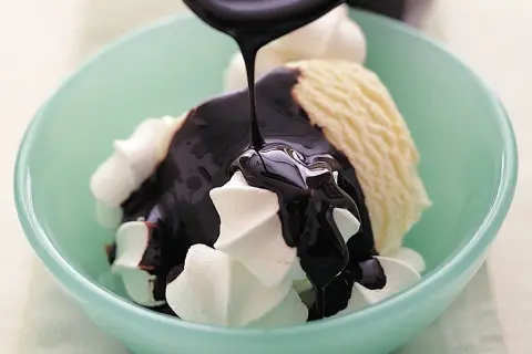 En skål med vaniljglass och visp täcks av en härlig, sockerfri chokladsås som ringlas över.
