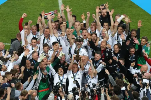 Piłkarze Legii świętują zdobycie kolejnego trofeum, podnosząc puchar. Ile mistrzostw Polski ma Legia? Tyle, ile radości na ich twarzach!