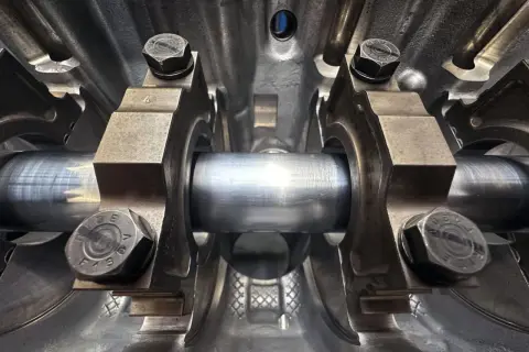 Detailaufnahme eines Motorgehäuses mit der Kurbelwelle eines Autos, die auf Lagerschalen ruht.