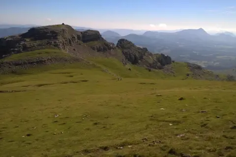 Vistas de **Gorbea desde Murgia**. Un paisaje montañoso verde y rocoso bajo un cielo azul claro.
