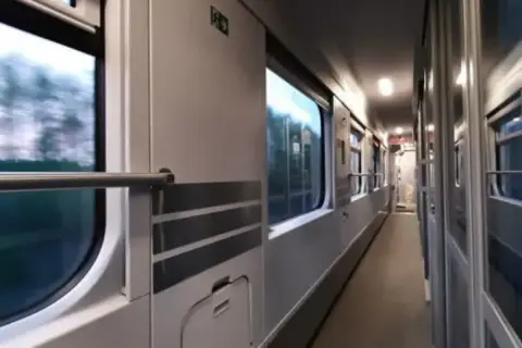 Korytarz pociągu PKP, podróż z Lublina do Kołobrzegu. Widok na okna i drzwi wagonu.