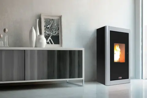 Stufa a pellet 12 kw quanti mq riscalda? Immagine di un moderno soggiorno con stufa a pellet accesa, mobile contenitore e decorazioni.
